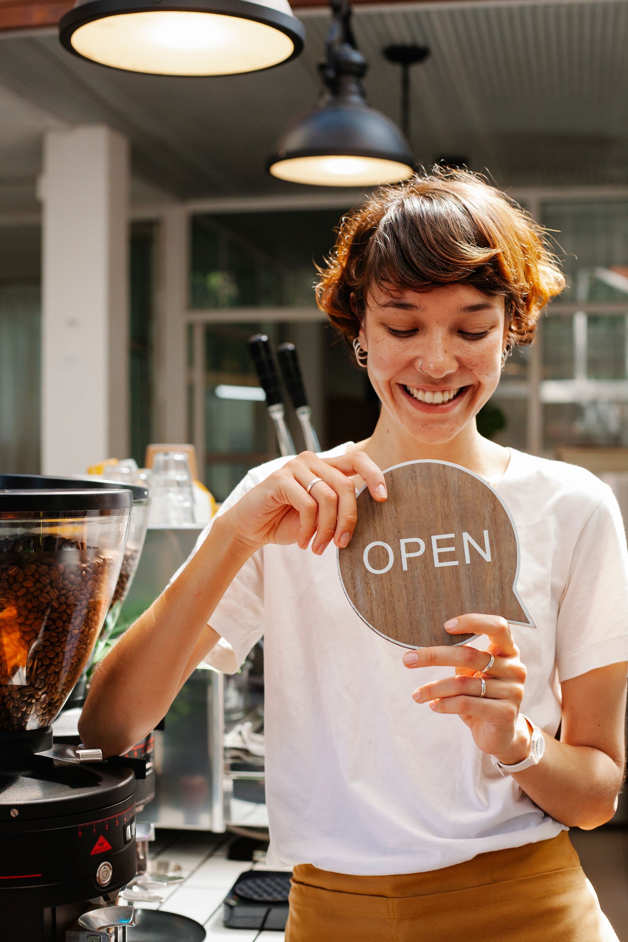 An owner turning the sign on her shop door to open
